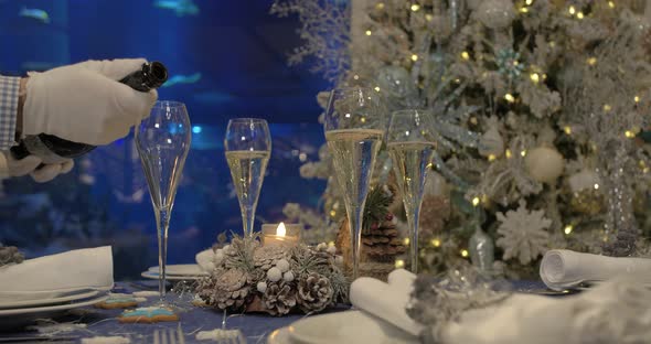 Dining table prepared for Christmas dinner, with a Christmas tree alt