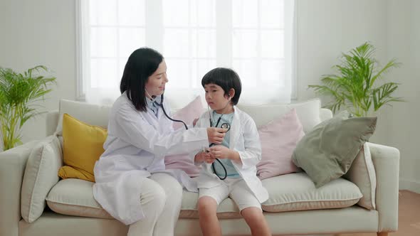 Asian family relationships, father, mother and son having fun playing doctor