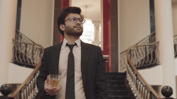 Successful Businessman with Whiskey Glass Walking alt
