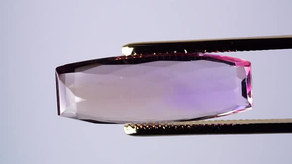 Natural Ametrine in the Tweezers on the Background