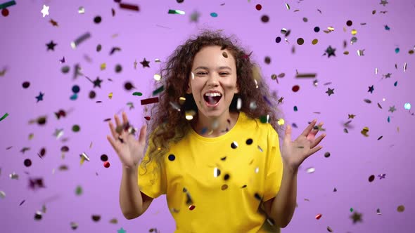 Happy Woman Dancing Having Fun Screaming WOW Rejoices Over Confetti Rain in Violet Studio alt