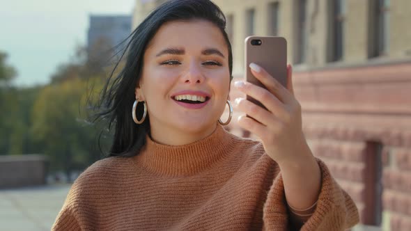 Closeup Happy Young Woman in City Outdoors Communicating By Video Call Online From Mobile Gadget alt