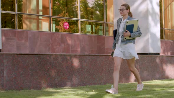 the Young Student Dressed in a Dress Goes Happily to the University alt