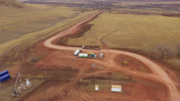 A Dynamic Frame in Which a Huge Yellow Caterpillar Bulldozer Lit By the Sun Against a Blue Sky Calls alt