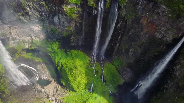 Aerial view above waterfall surrounding by jungle, Faroe Island. alt