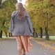 Back View of a Slim Caucasian Woman in Checkered Jacket and Mustard Dress Walking in the Autumn Park