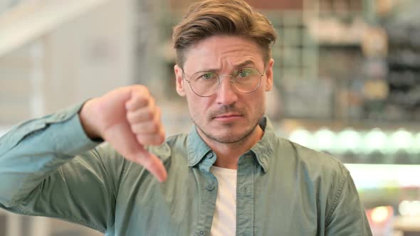 Portrait of Disappointed Middle Aged Man Doing Thumbs Down alt