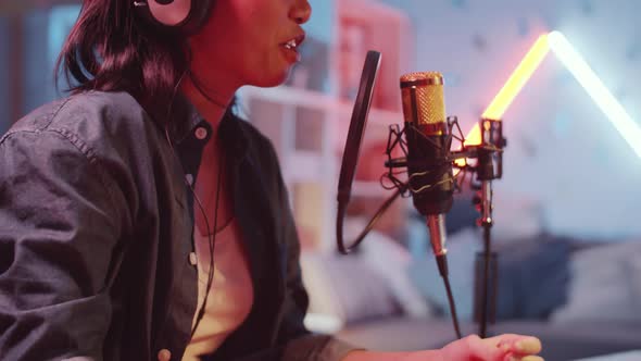 Asian Woman Singing in Mic and Using Sound Mixer in Home Recording Studio alt