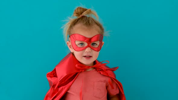 Funny Girl in Red Superhero Costume with Mask Waves Hand alt