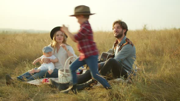 Happy Boy Playing with Parents During Picnic