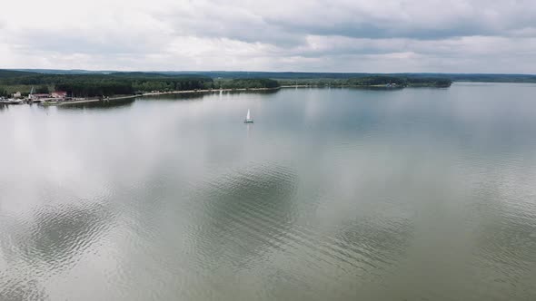 The Drone Slowly Flies Over a Sailing Boat in the Lake