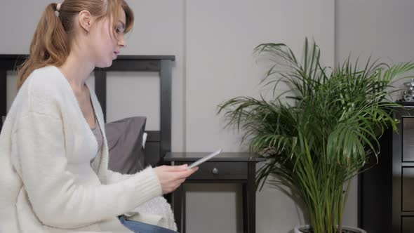 Woman Using Tablet in Bed Reacting to Loss alt