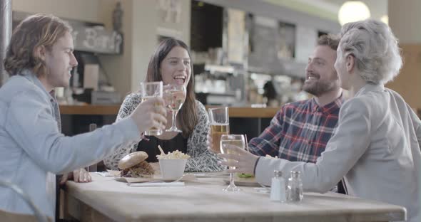 Men and women enjoying wine and beer while sitting in pub