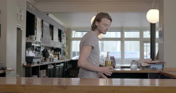 Man holding full glass of beer and serving in pub