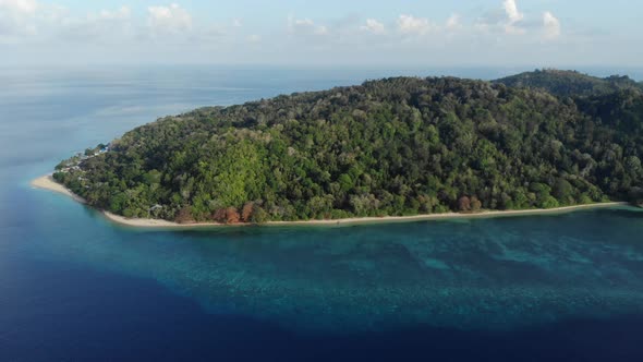 Aerial: flying over tropical Hatta island white sand beach Banda Islands Maluku alt