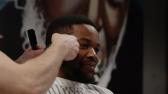 White Guy Doing a Haircut to a Young Joyful African American Guy in a Beautiful Barbershop