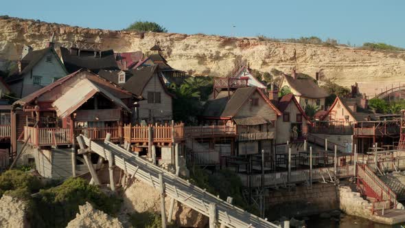 Popeye Village Establisher in Anchor Bay, Gozo Island, Malta Wooden Village Houses By Water, Aerial alt
