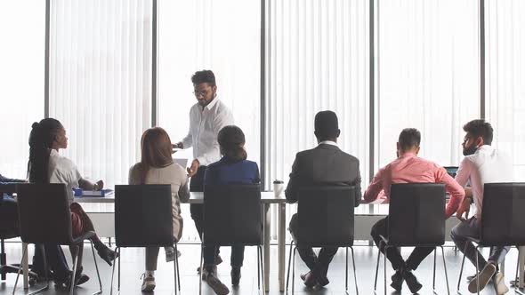 Mixed Race People Listening to Presentation Sitting in Row at Boardroom Table alt