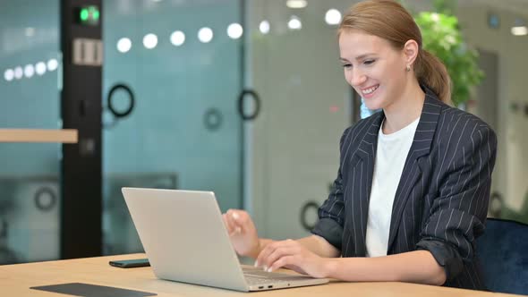 Excited Young Businesswoman Doing Video Call on Laptop in Office alt