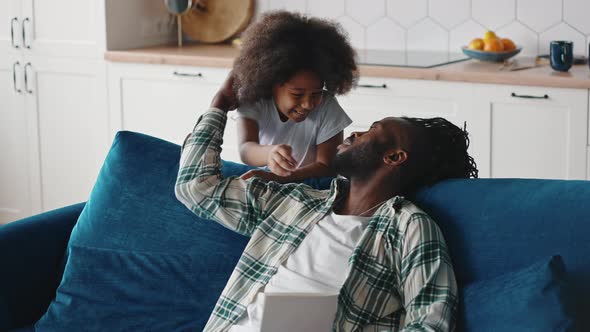 Little Girl Presenting Handmade Greeting Card to Her Daddy Happy Man Enjoying Great Gift and Hugging alt