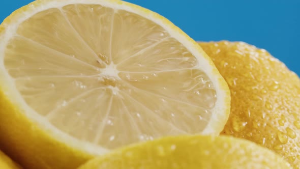 Lemons Isolated on Blue Background Pouring Water on Fresh and Ripe Citrus Fruits alt