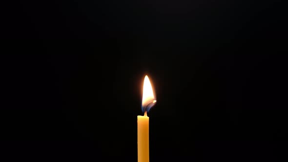 Single candle flame isolated on black background, Close up. alt