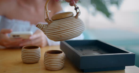 A Set of Tea Chinese Tea Pouring Into the Cups on the Wooden Table Outdoors Man Takes Pot and Pour alt