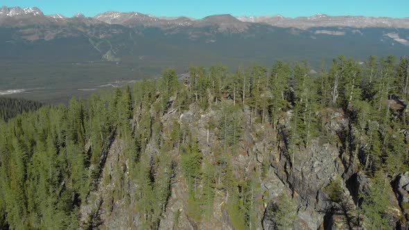 Aerial Drone View Flight over pine tree forest in Mountain during the day, Banff Canada alt