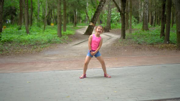 Beautiful little girl dancing in city Park on nature background