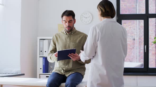 Male Patient Signing Papers and Doctor at Hospital alt