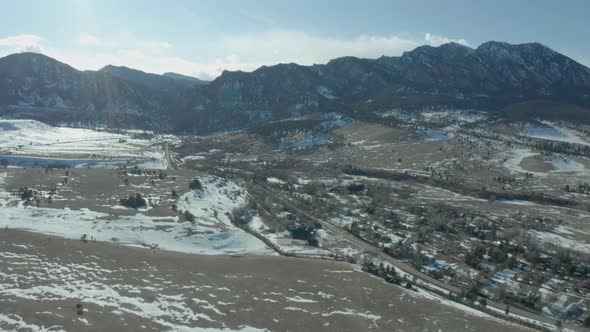 Aerial Drone Shot Over Snowy Colorado Plains With Front Range In Background alt