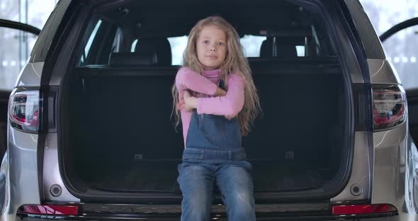 Cheerful Caucasian Little Girl Showing Car Keys, Crossing Hands and Smiling. Joyful Child alt