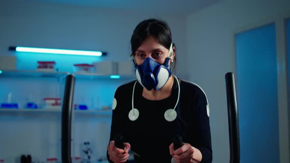 Tired Athlete Woman Training on Cross Trainer Increasing Rhythm of Exercises alt