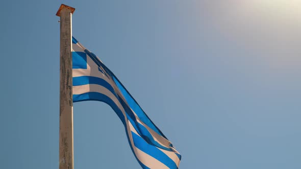 Greek Flag on the Pillar Waving on the Wind Over Sky Background alt