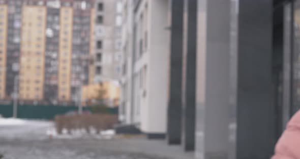 Coronavirus Protection. A Caucasian Girl Wearing Protective Mask Walking on a Street