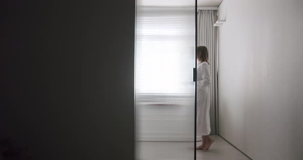 Woman in Robes Open Transparent Sliding Door Inside the Modern Bathroom alt