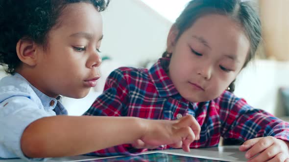 Multiethnic Boy and Girl Playing on Digital Tablet