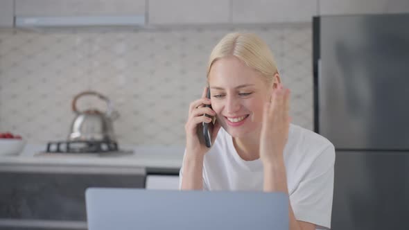Attractive Blonde Woman is Excited and Laughs During Phone Call at Home alt
