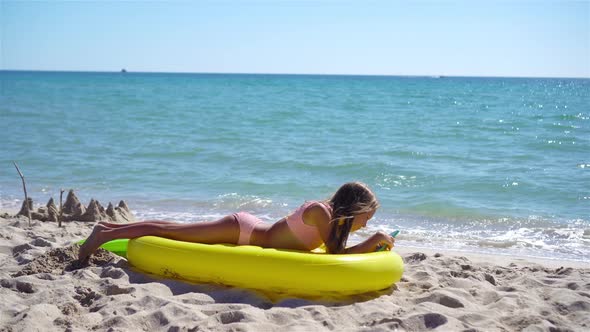 Adorable Girl on Inflatable Air Mattress on the Beach