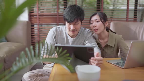 home finance,husband and wife discussing paper bill receipt from tablet laptop together