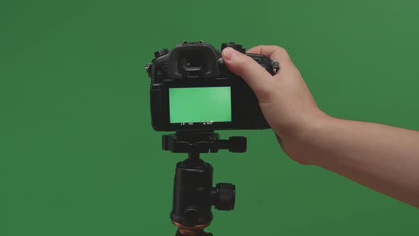 Male Hand Taking Photos With Green Screen Display Camera In Green Background alt