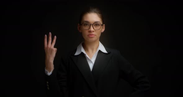 Business Woman with Glasses with a Serious Face Shows Three Finger