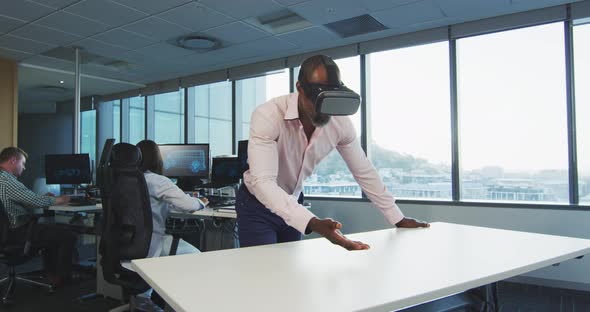 African American businessman wearing VR headset in modern office alt