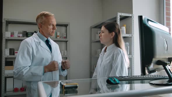 Two Confident Caucasian Pharmacists Talking About Medicine Indoor of Pharmacy alt