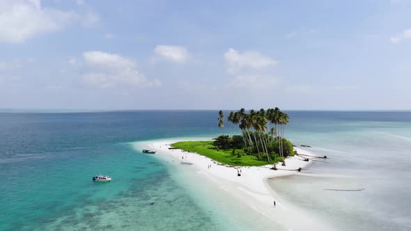 Cinematic aerial view of a beautiful small island beach in the middle of the ocean