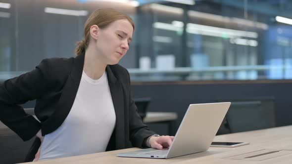 Businesswoman Having Back Pain While Using Laptop alt