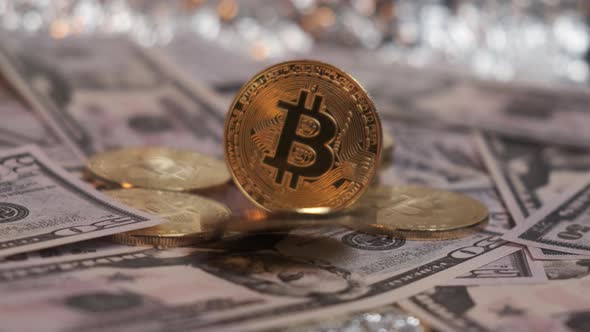 The Bitcoin Coin Rotates and Falls Against the Background of Dollar Bills alt