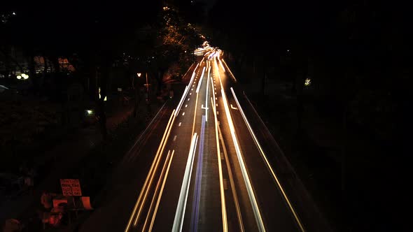 Time lapse of night traffic, cars and motorbikes driving on road in Ho Chi Minh city. Car headlights alt