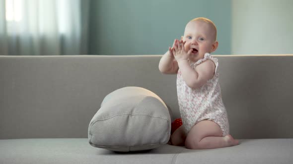 Healthy Baby Playing in Good Mood, Clapping Hands and Laughing, Happy Childhood alt