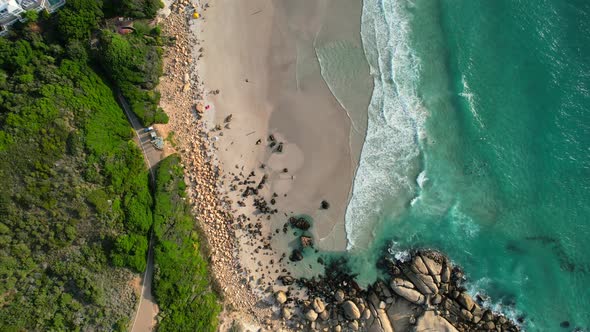 top down view of rocky coastline and turquoise blue ocean waves on pristine white sand Llandudno Bea alt